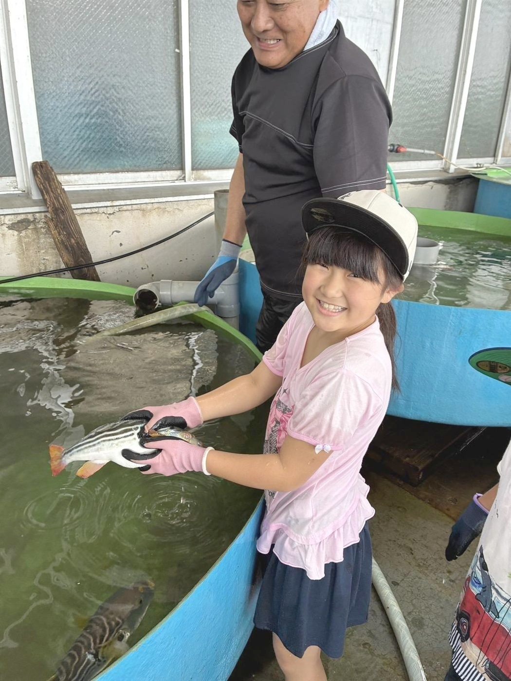 魚を持って笑顔の女の子