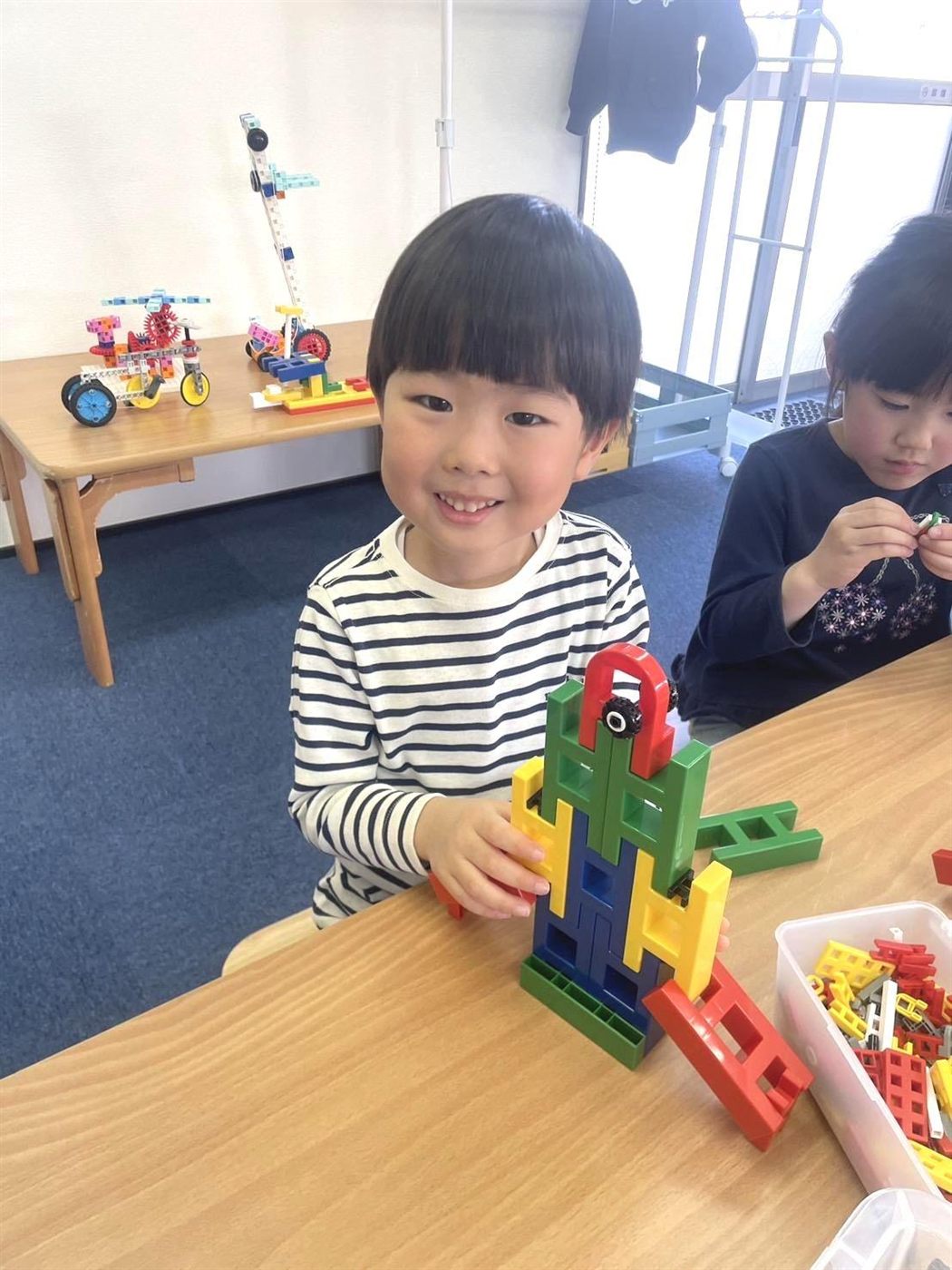 自分でつくった作品を前に笑顔の子ども