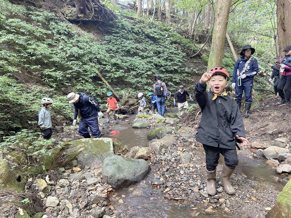 森の沢で笑顔を見せる子ども